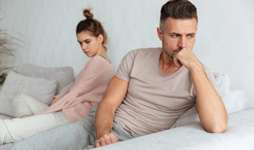 Image of Quarrelled lovely couple sitting separately on couch at home